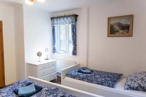 útulná ložnice v přízemí s krásným bílým nábytkem a obrazem