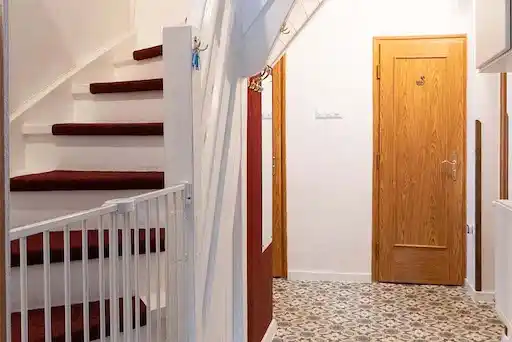 chodba v přízemí se schodištěm zabezpečeným dětskou brankou